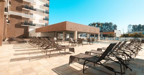 a group of chairs and tables and a building at Spazzio DiRoma / Acqua park in Caldas Novas