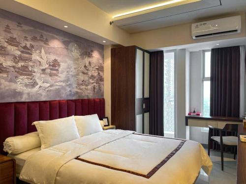 een slaapkamer met een bed met een schilderij aan de muur bij Oriental La Casa V at Anderson in Surabaya