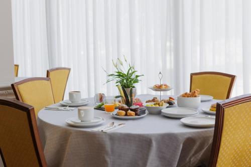 a table with plates of food on it at Parco dei Principi Boutique Hotel in Rimini