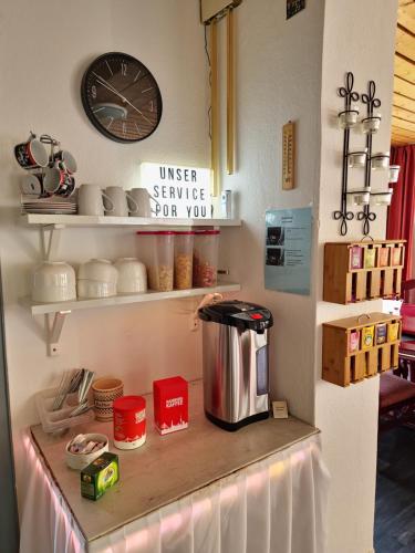 a counter in a kitchen with a clock on the wall at Pension Hamburg in Bad Grund