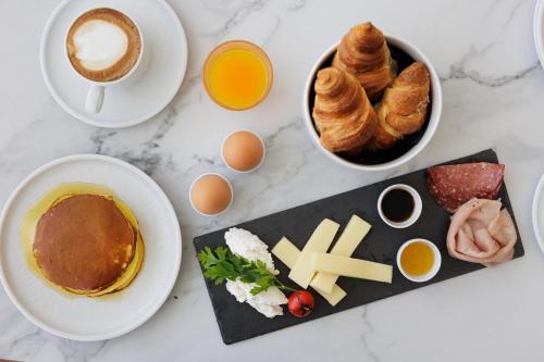 a table with breakfast foods and a cup of coffee at Parco dei Principi Boutique Hotel in Rimini