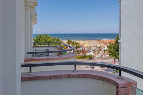 a balcony with a bench and a view of the beach at Parco dei Principi Boutique Hotel in Rimini