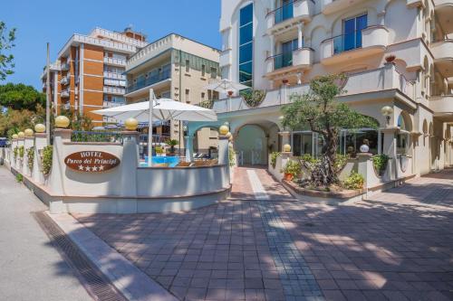 a street in front of a building with an umbrella at Parco dei Principi Boutique Hotel in Rimini