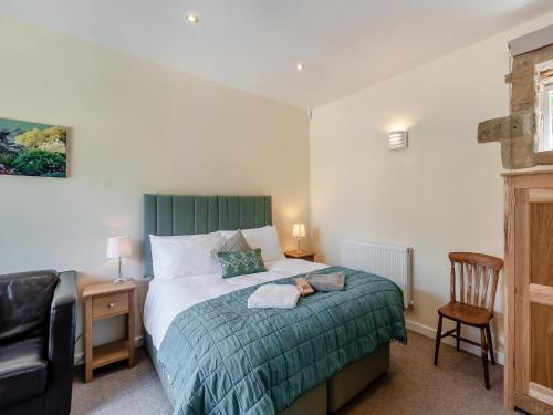 a bedroom with a bed with a dog laying on it at Church Cottage in Two Dales