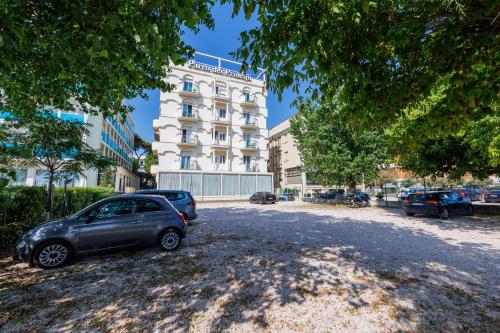a car parked in a parking lot in front of a building at Parco dei Principi Boutique Hotel in Rimini
