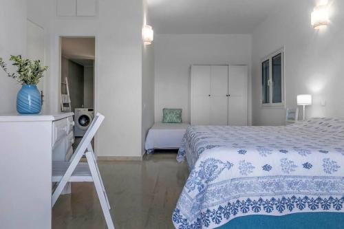 a bedroom with a bed with a blue and white blanket at Villa Big Blue in Mavrovoúnion