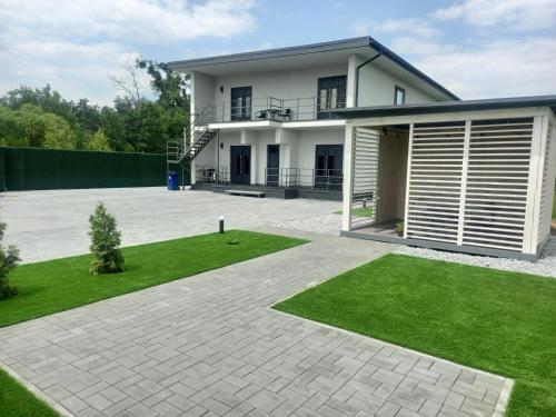 a large white house with a lawn in front of it at apartments Best time to rest in Glubochitsa