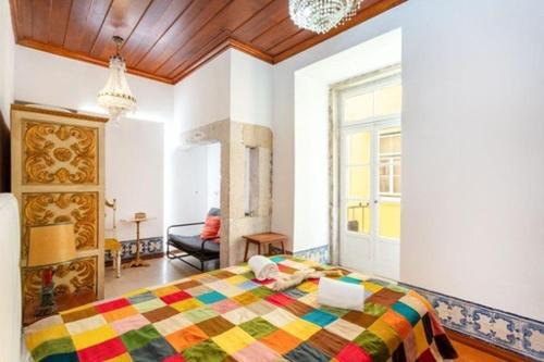 a bedroom with a colorful bed and a living room at Historic Center romantic apartment in Lisbon