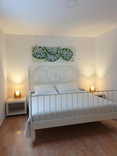 um quarto com uma cama branca com duas luzes em El Caramelito 3 em San Bartolomé