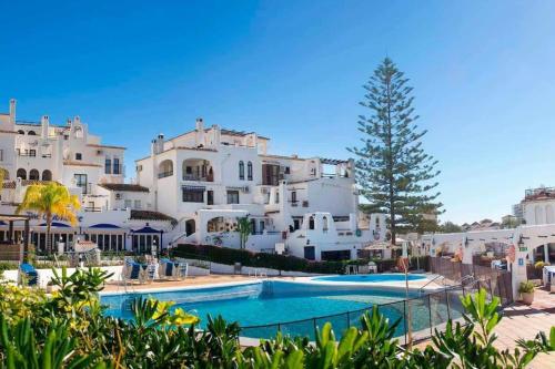 a pool in front of a large white building at Elegant 2-bedroom apartment with beautiful views in Benalmádena