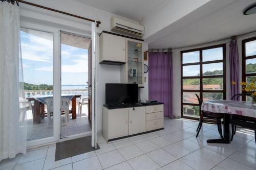 a living room with a television and a balcony at Kuća Zora in Zaglav