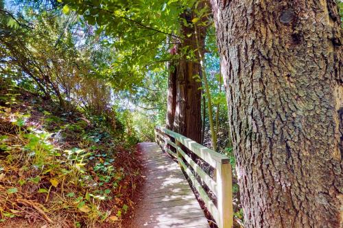 a wooden path with a fence next to a tree at Calamity Cabin in Gig Harbor