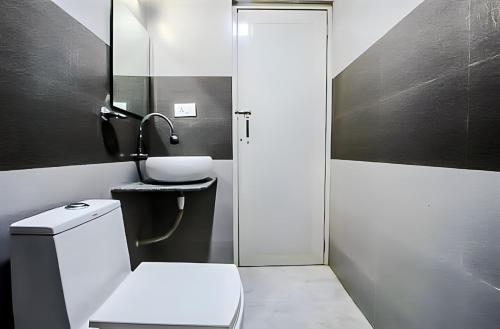 a bathroom with a toilet and a sink and a mirror at Calangute Turista in Calangute