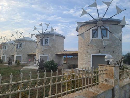 a building with three wind turbines on top of it at Temeni windmills in Témeni