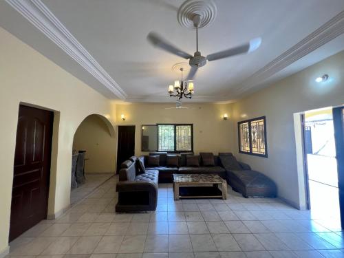 a living room with a couch and a ceiling fan at Villa Saran in Bamako