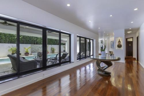 a living room with a table and chairs and windows at Luxury Zen Retreat home in Princeville
