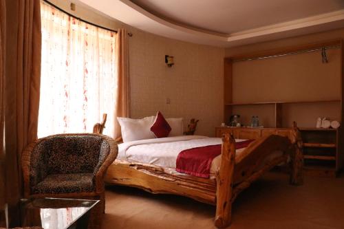 a bedroom with a bed and a chair and a window at Brooks Lodge in Nakuru