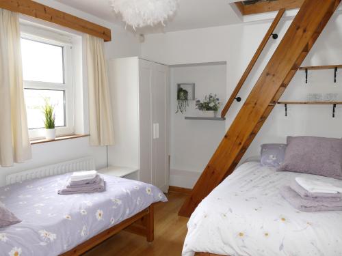 a bedroom with a bed and a wooden staircase at Carol Cottage in Newry