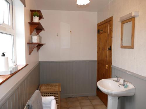 a bathroom with a sink and a toilet and a mirror at Carol Cottage in Newry