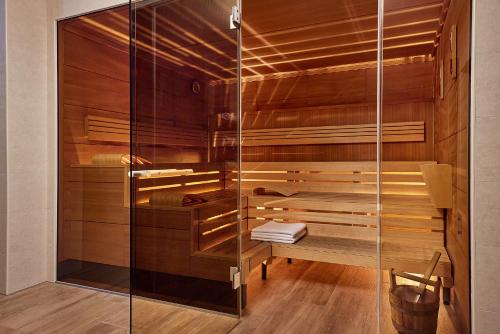 un sauna avec des murs en bois et une porte en verre dans l'établissement AC Hotel by Marriott Innsbruck, à Innsbruck