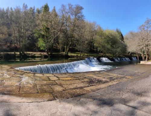 a waterfall on the side of a river at Casa da Rapadoira in Laxoso de Abaixo