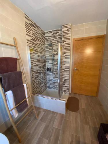 a bathroom with a shower and a glass door at Casa da Rapadoira in Laxoso de Abaixo
