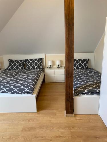um quarto com duas camas e duas mesas de cabeceira em Pokoje I Domki WIKTORIA em Będzino