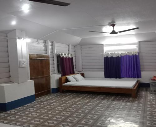 a bedroom with a bed and a ceiling fan at DOOARS VELLEY HOME STAY in Buxa Duār