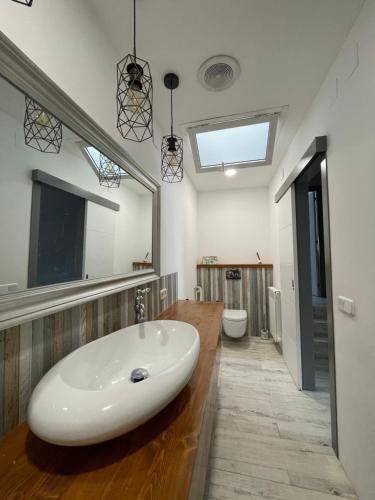 La salle de bains est pourvue d'un grand lavabo blanc et d'un miroir. dans l'établissement Casa con piscina cerca de la playa, à Vidreres