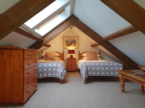 a attic bedroom with two beds and a skylight at Ty Barcud in Lampeter
