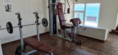 um quarto com um ginásio com uma cadeira e pesos em Precioso piso con unas vistas increíbles em Benidorm