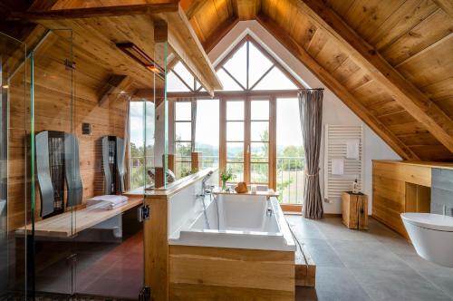 een badkamer met een groot raam, een bad en een wastafel bij Bergdorf LiebesGrün in Schmallenberg