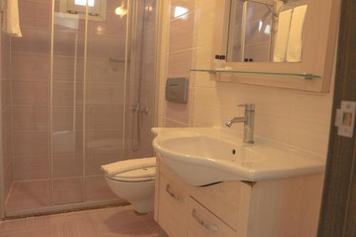 a bathroom with a sink and a toilet and a shower at Hawaii Suite Beach Hotel in Alanya
