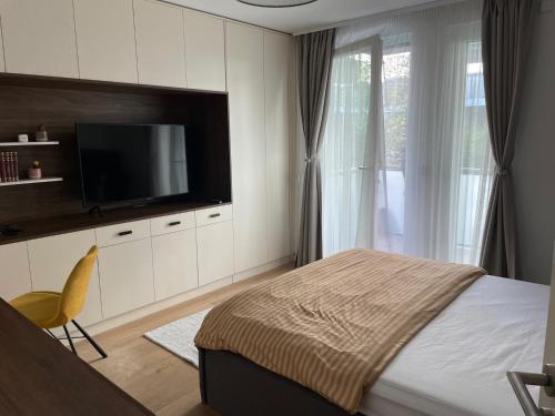Un dormitorio con una cama y un televisor de pantalla plana. en The Garden Loft, en Frankfurt