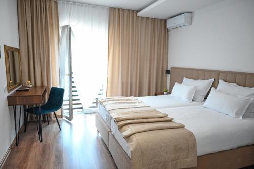 una camera con letto, scrivania e finestra di Hotel Premium a Jajce