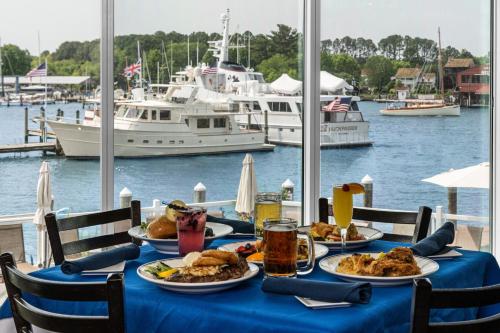 a table with plates of food and boats in a marina at St Michaels Harbour Inn, Marina and Spa in Saint Michaels