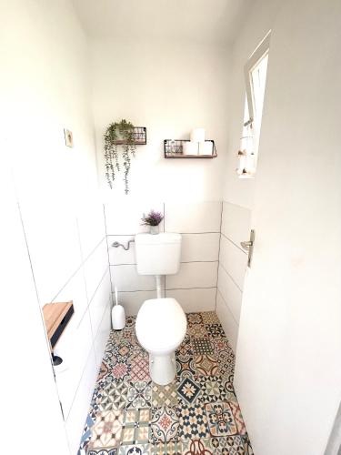 a bathroom with a toilet and a tile floor at Landhaus mit Garten in Neutal