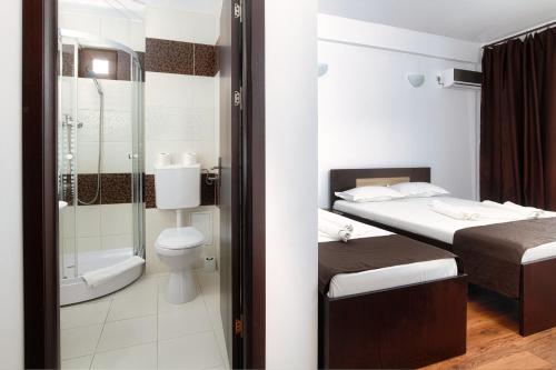 a small bathroom with two beds and a shower at Vila 21A in Costinesti