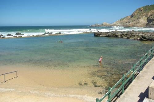 a person standing in the water at the beach at The Third Dolphin in Herolds Bay