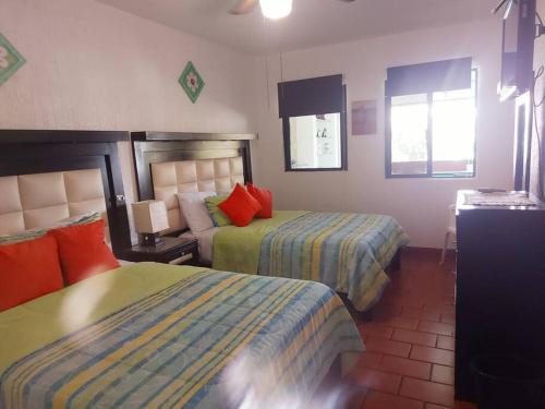 a hotel room with two beds and a window at Casa en Club de Golf Santa Fe in Temixco