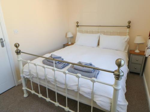 a bedroom with a white bed with towels on it at 66 Dale Grove in Leyburn