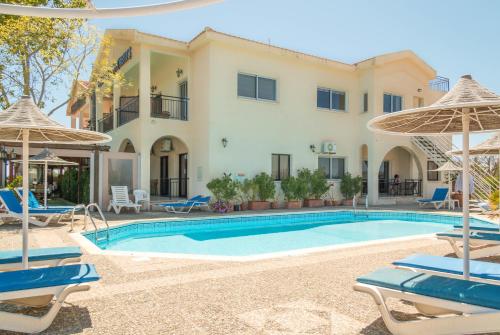 a villa with a swimming pool and patio furniture at Hill View Hotel Apartments in Pissouri