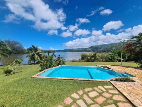 una piscina en el césped junto a un cuerpo de agua en Te Mana Lodge, en Taravao