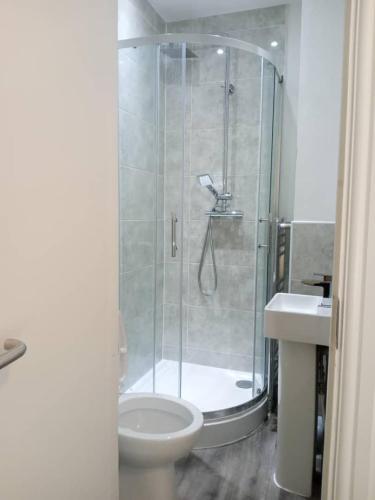 a bathroom with a shower and a toilet and a sink at Double-bed (H2) close to Burnley city centre in Burnley