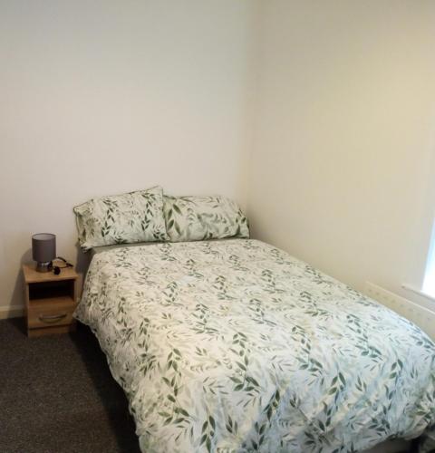 a bedroom with a bed and a night stand at Double-bed (H2) close to Burnley city centre in Burnley