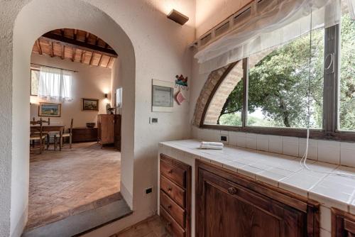 ポッジボンシにあるCasale di Villoreの大きな窓付きのキッチン、ダイニングルームが備わります。