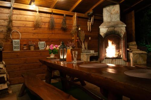 comedor con chimenea en una cabaña de madera en Apartament w Alejce, en Rabka