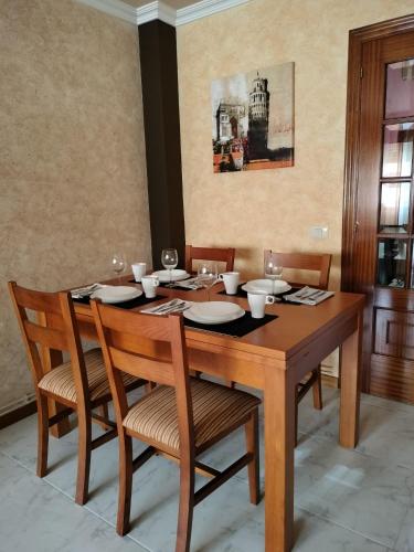 a dining room table with two chairs and a table with glasses at Piso Pauser in Puentecesures