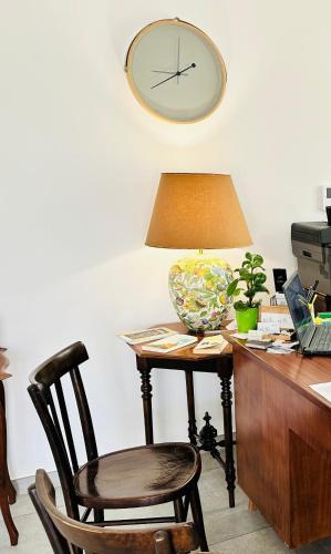 a desk with a chair and a clock on the wall at InVilla Bed&Breakfast - Quality Rooms in Santa Maria di Castellabate