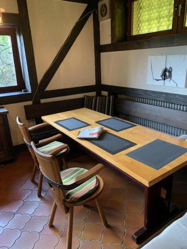 a wooden table and chairs in a room at Auszeit auf dem KulturGut Hirtscheid in Hirtscheid